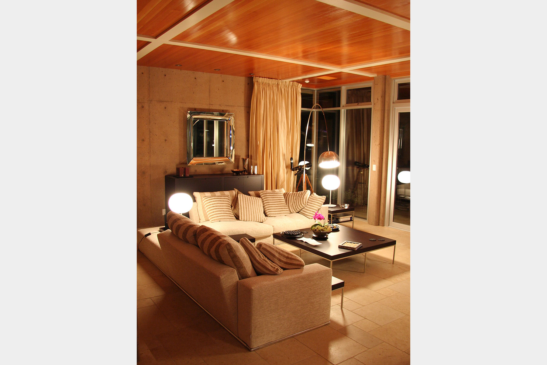 Evening lounge — concrete walls, wood ceiling and soft light