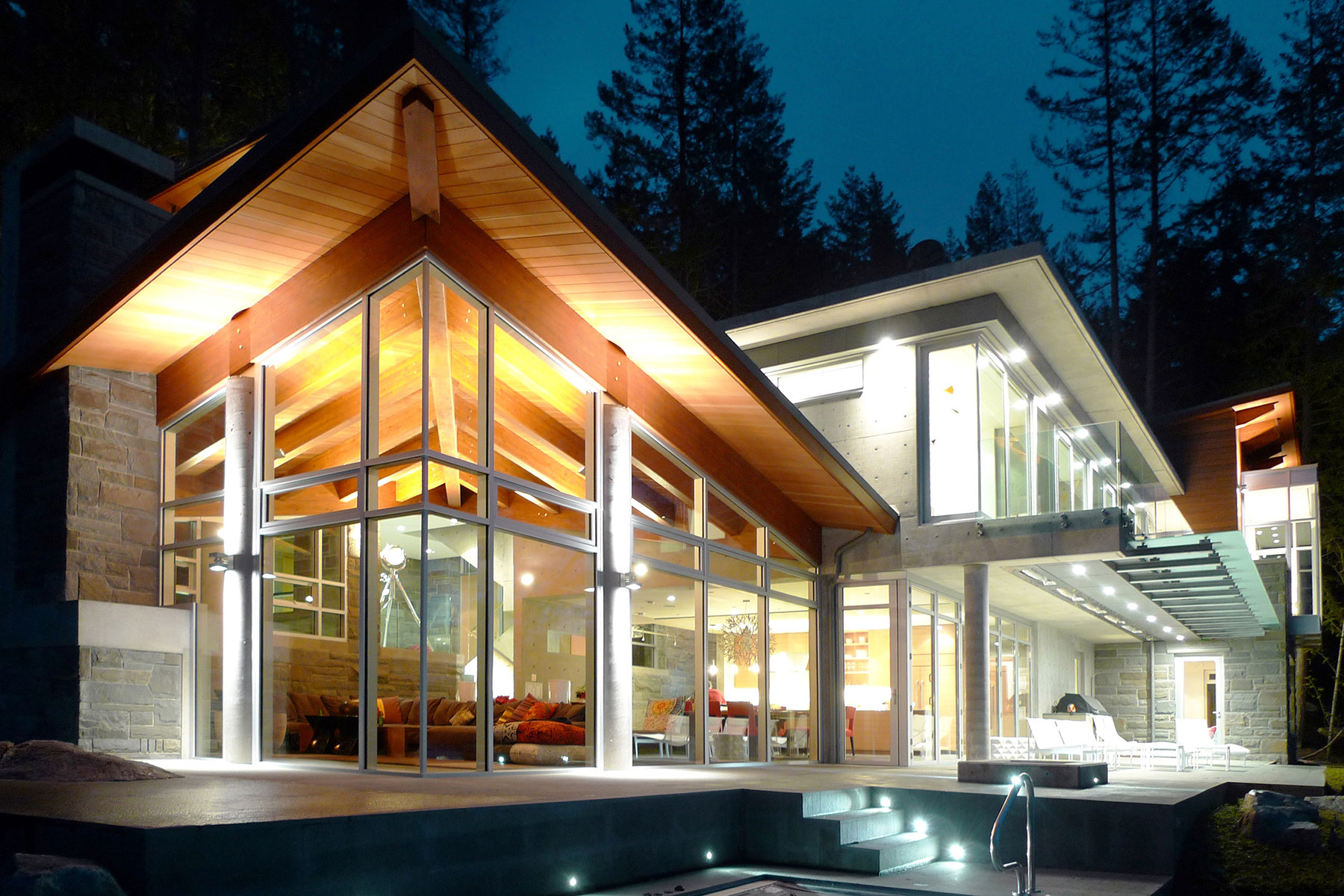 Sunshine Coast Retreat — timber, stone and glass living pavilion glowing at dusk beside the pool terrace