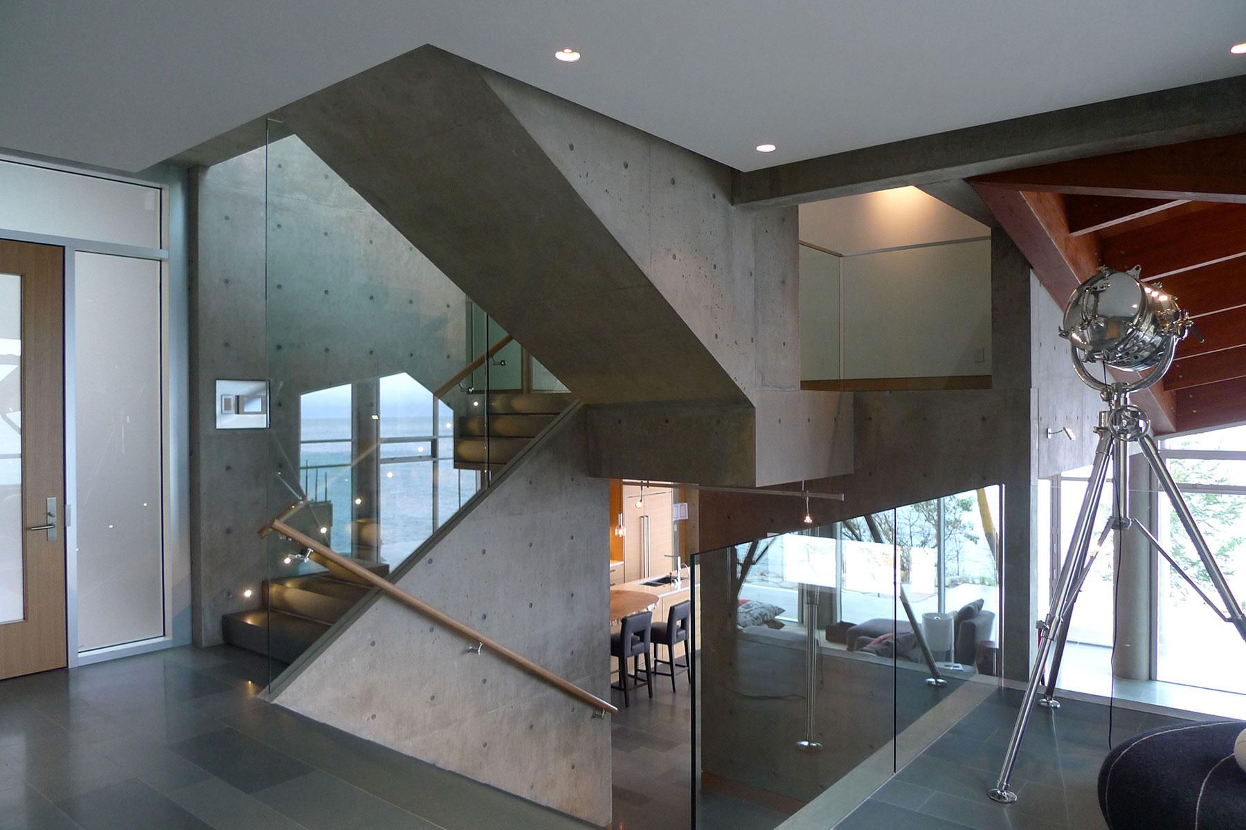 Board-formed concrete stair rising through the main hall