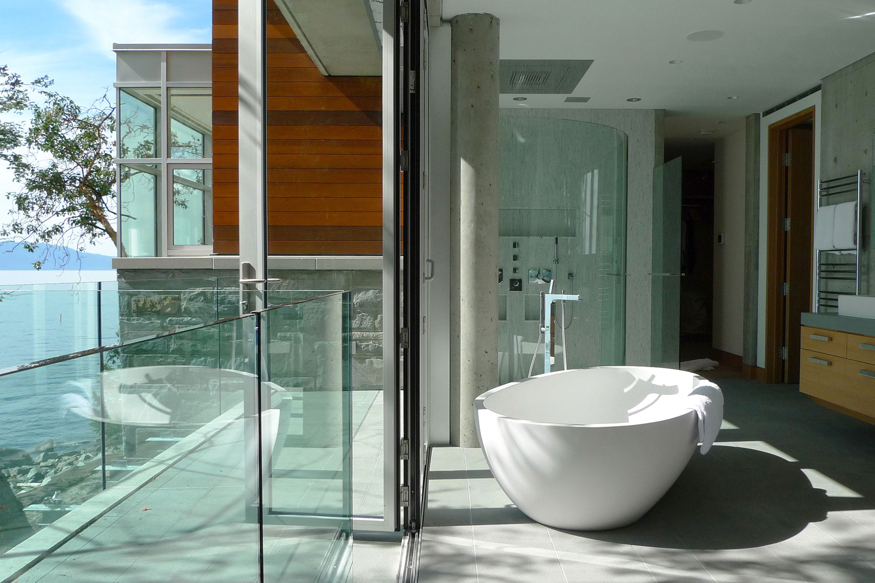 Master bath — freestanding sculptural tub beside bifolding glass doors to the terrace