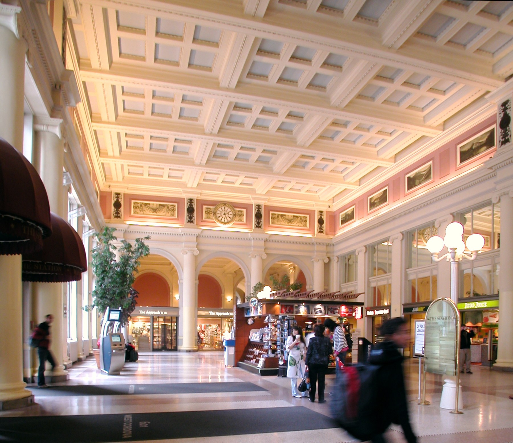 The coffered concourse hall with its shops and lamps