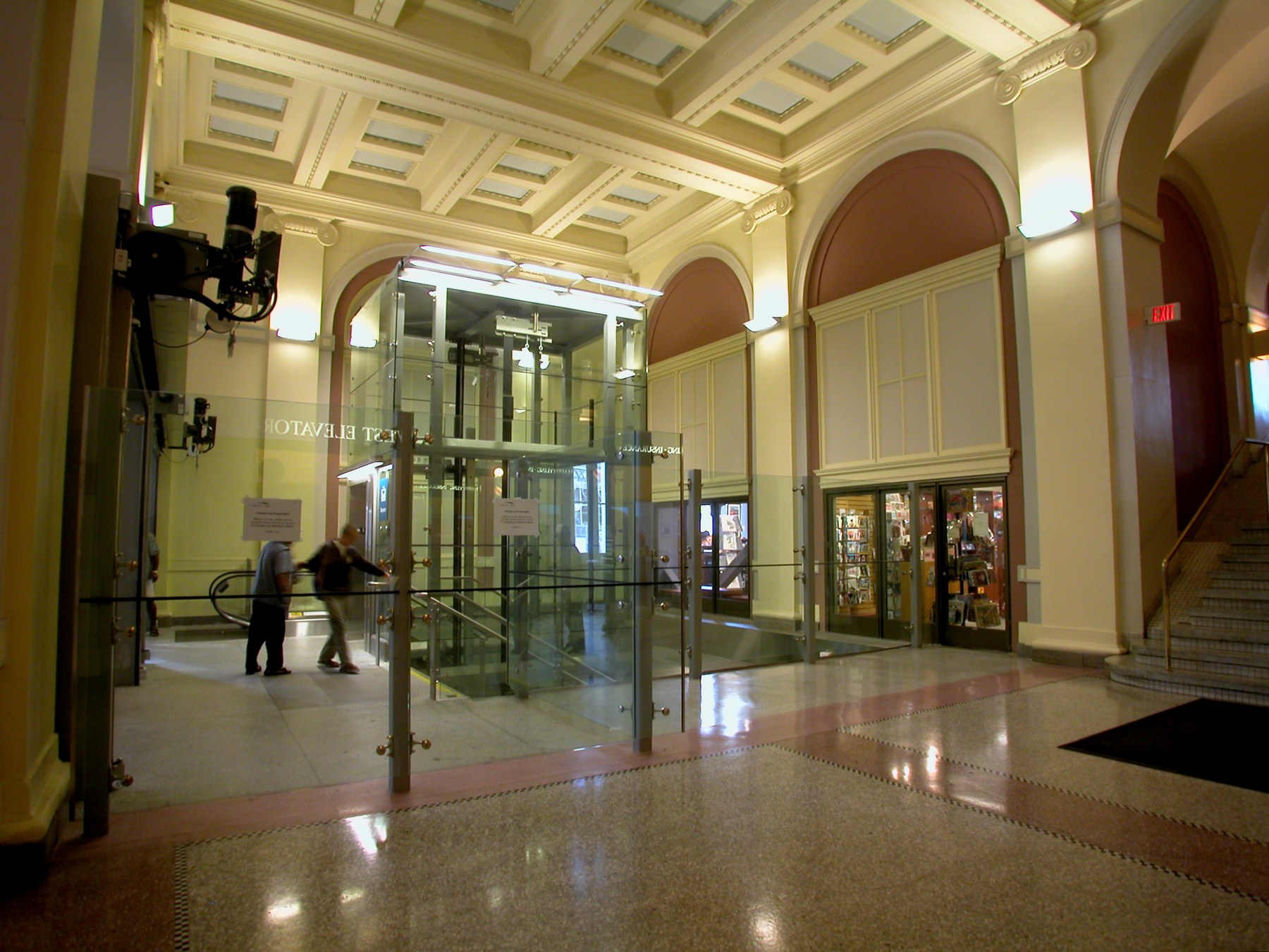 The glazed elevator and entrance seen across the concourse